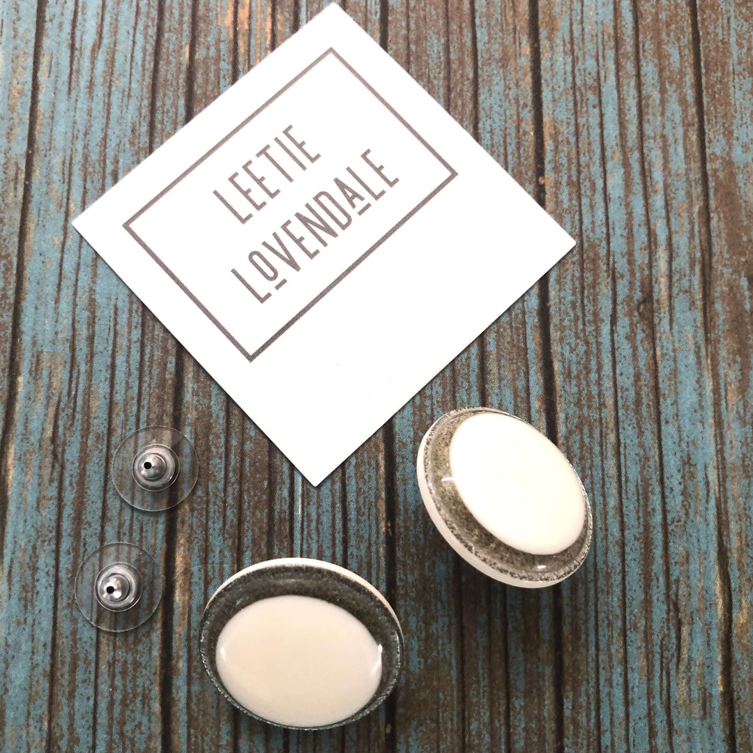 Vintage beveled disc studs in white resin & silver glitter, 24mm. Surgical steel posts, lightweight. 1960s Lucite, handcrafted in the USA.