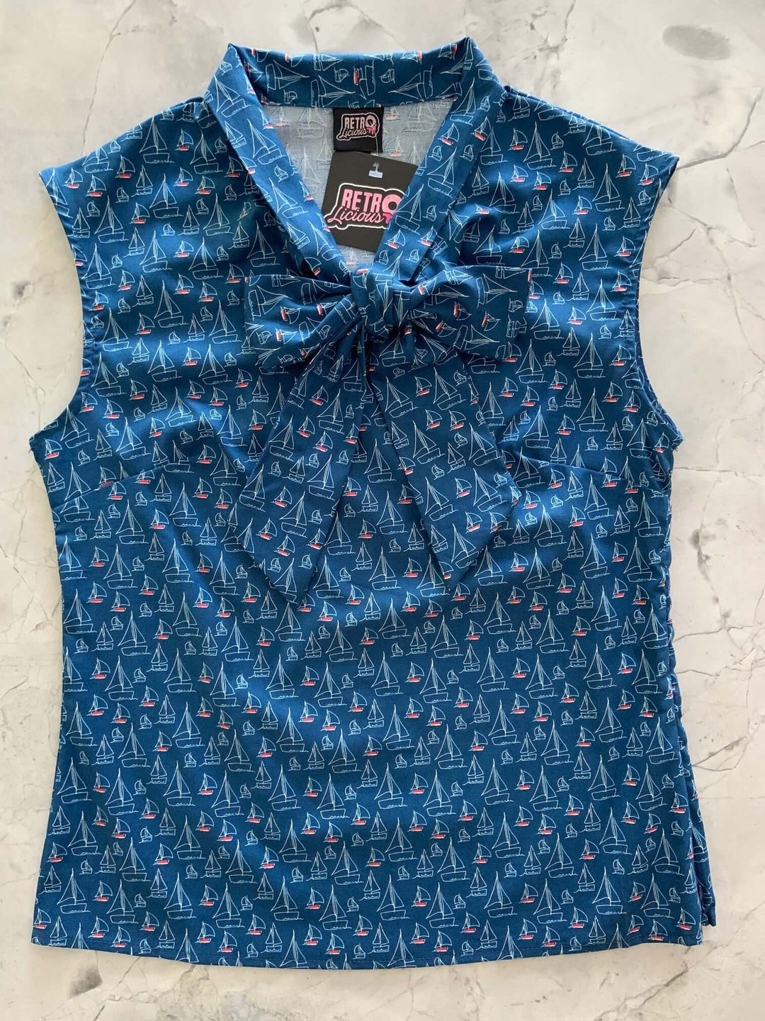Vintage Tops This top is for the vintage lover at heart! Shown in our sailboats print, this 100% cotton top features bust darts for a flattering silhouette, a side zippered closure for ease of wear, and an oversized bow at the neckline for that perfect 1950&