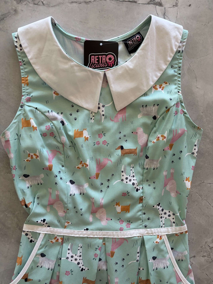 Shop the Dogs Collared Dress by Retrolicious — 60s-style A-line, dog print, Peter Pan collar, pockets, 100% cotton. Made in USA. Sizes XS–4X.