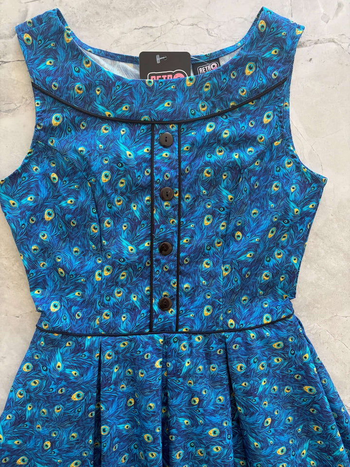 Shop the Elizabeth Dress by Retrolicious — vintage peacock print, piping details, knee length, pockets, 100% cotton. Made in USA. Sizes XS–4X.