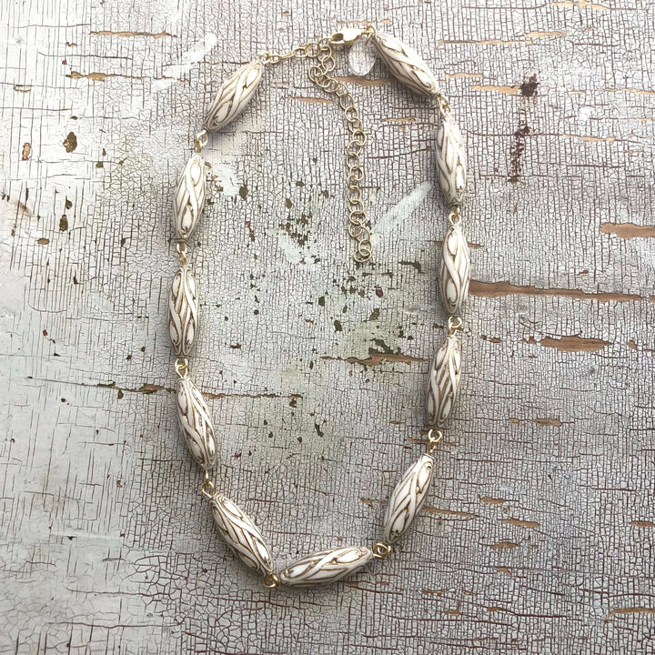 Gold-lined art nouveau white Lucite beads, hand-linked rosary style with laser-cut pendant. 1960s deadstock, 16" + 6" extender. Made in USA.