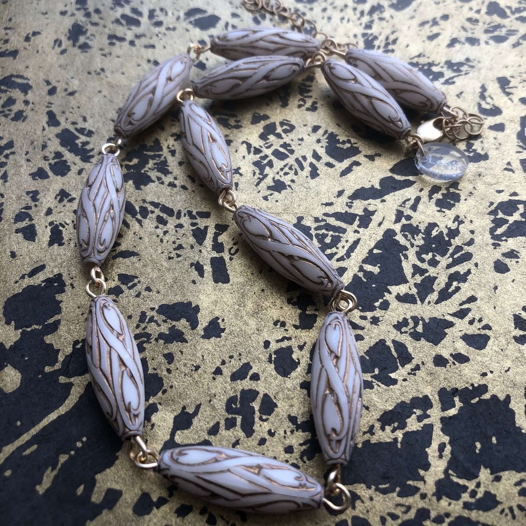 Gold-lined art nouveau white Lucite beads, hand-linked rosary style with laser-cut pendant. 1960s deadstock, 16" + 6" extender. Made in USA.