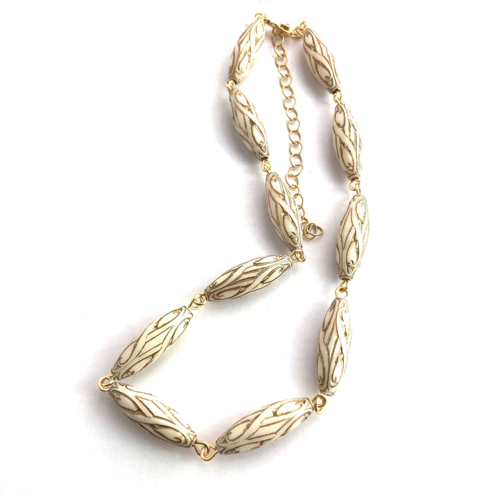 Gold-lined art nouveau white Lucite beads, hand-linked rosary style with laser-cut pendant. 1960s deadstock, 16" + 6" extender. Made in USA.