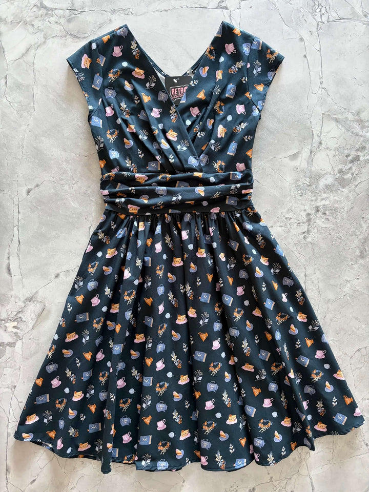 Shop the Tea Party Greta Dress by Retrolicious — vintage V-neck, gathered waist, knee length, pockets, 100% cotton. Made in USA. Sizes XS–4X.
