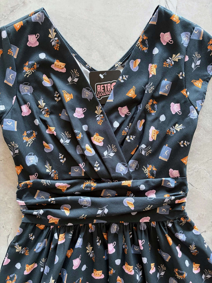 Shop the Tea Party Greta Dress by Retrolicious — vintage V-neck, gathered waist, knee length, pockets, 100% cotton. Made in USA. Sizes XS–4X.