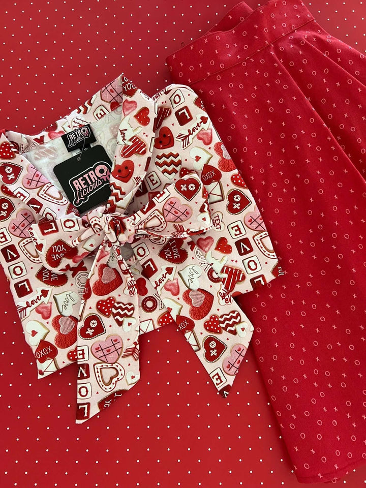Vintage Tops This top is for the vintage lover at heart! Shown in our XOXO print, this 100% cotton top features bust darts for a flattering silhouette, a side zippered closure for ease of wear, and an oversized bow at the neckline for that perfect 1950&
