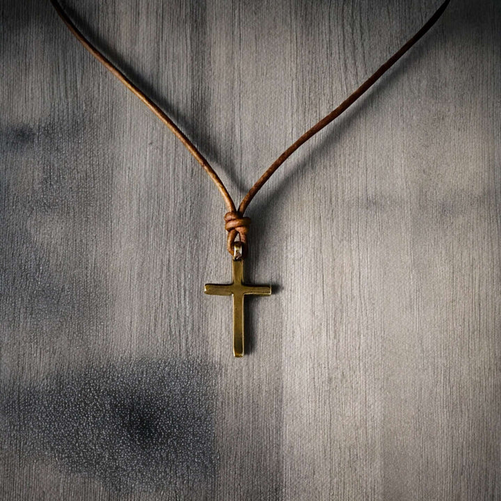 Handcrafted solid bronze cross on an adjustable leather cord. Unisex, red brown or dark brown. Made in USA with a lifetime warranty