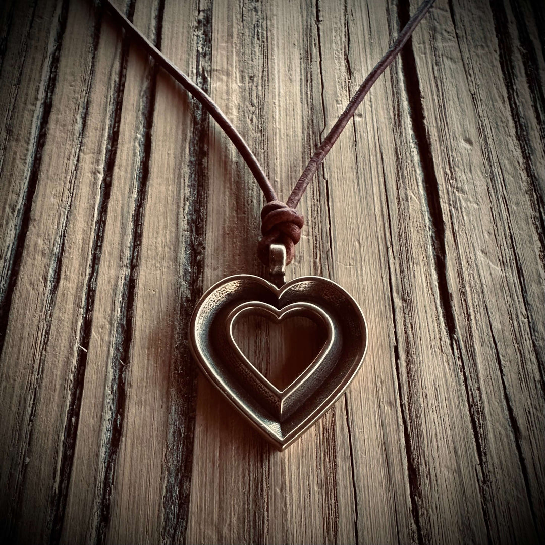 Handcrafted solid bronze LOVE heartbeat necklace on an adjustable leather cord. Made in USA with a lifetime warranty