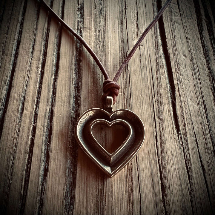Handcrafted solid bronze LOVE heartbeat necklace on an adjustable leather cord. Made in USA with a lifetime warranty