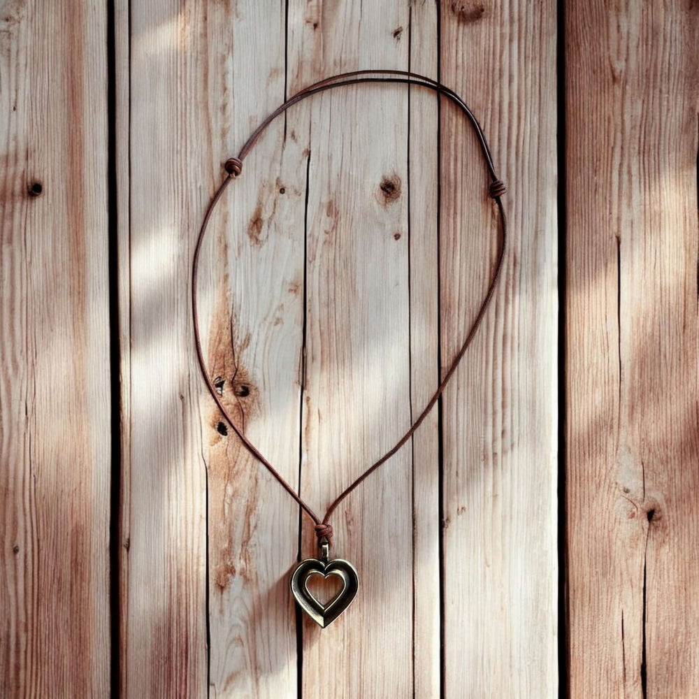 Handcrafted solid bronze LOVE heartbeat necklace on an adjustable leather cord. Made in USA with a lifetime warranty