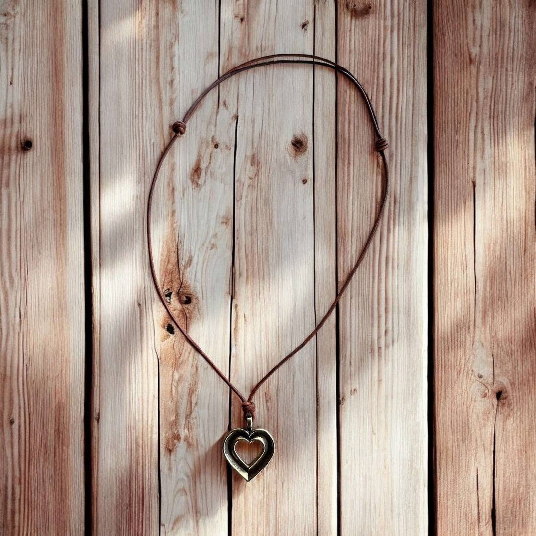 Handcrafted solid bronze LOVE heartbeat necklace on an adjustable leather cord. Made in USA with a lifetime warranty