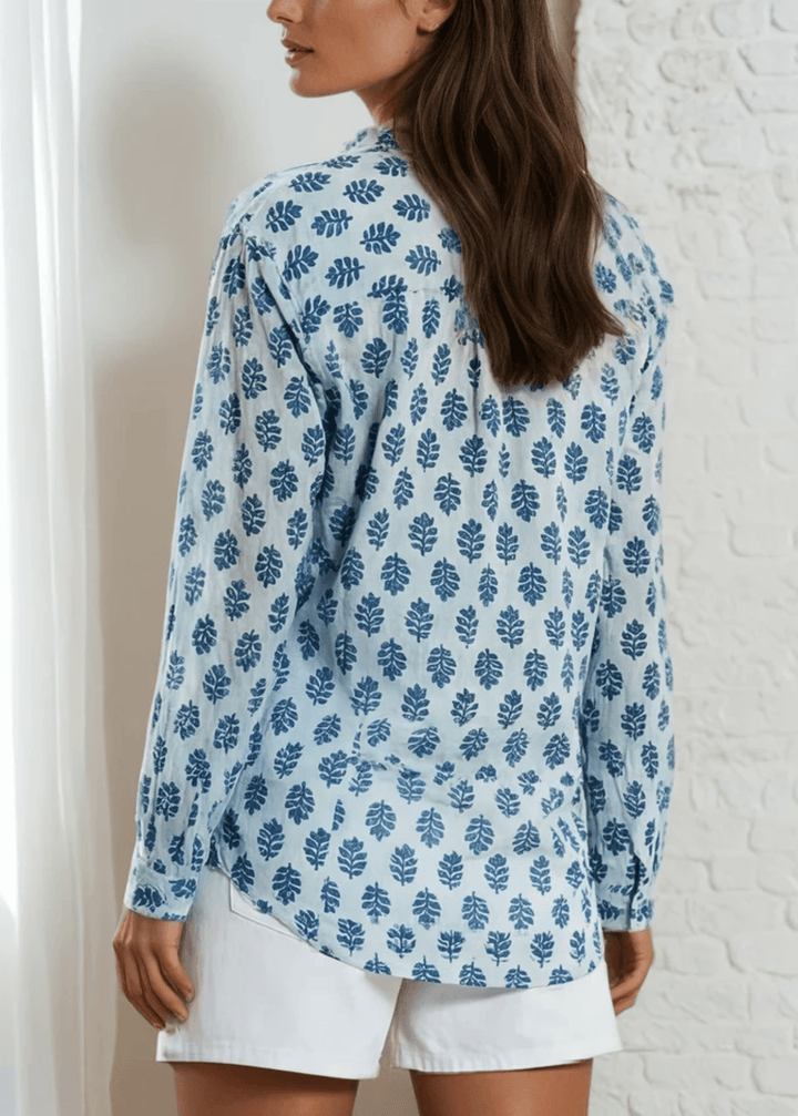 Effortless elegance meets everyday comfort in this Made in USA vintage-washed cotton-voile button-down. Hand-block inspired indigo florals dance across a serene sky-blue canvas, creating a timeless aesthetic that transitions seamlessly from casual to polished. The lightweight, breathable 100% cotton construction keeps you cool and comfortable.