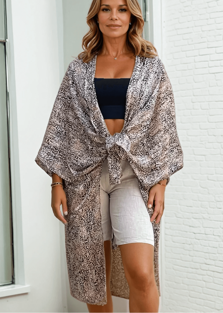 The Drapey Silhouette Kimono Cardigan elevates any look with its elegant, oversized design and shawl-style open front. Made from in USA 100% polyester with lurex accents
