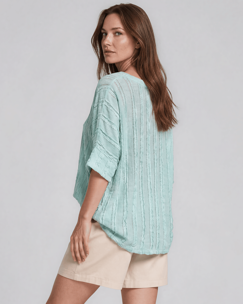 Shop the Laurel Textured Top in Aqua Blue — a relaxed oversized v-neck with striped lace effect, contrast sleeve bands & side slit. Made in USA.