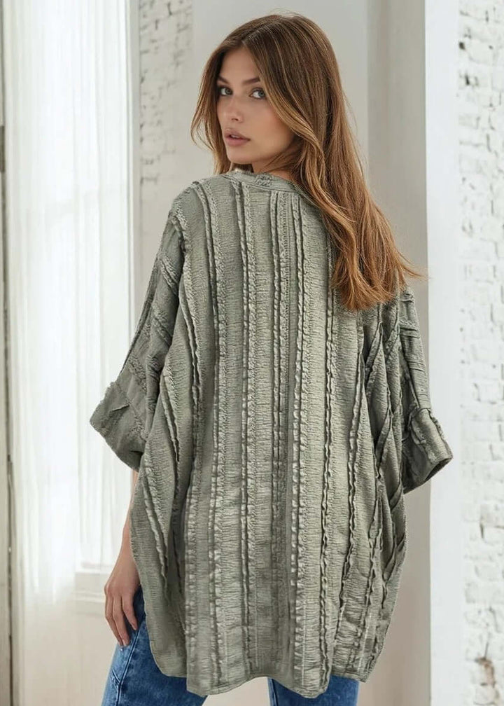 Elevate your everyday wardrobe with the Laurel Textured Top in Off White or Sage Green, a versatile Made in USA essential. This textured oversized v-neck features a delicate striped lace effect and half sleeves contrasting bands for a polished look. 