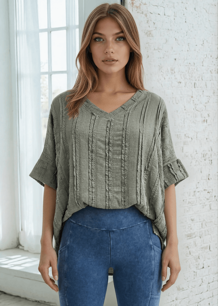 Elevate your everyday wardrobe with the Laurel Textured Top in Off White or Sage Green, a versatile Made in USA essential. This textured oversized v-neck features a delicate striped lace effect and half sleeves contrasting bands for a polished look. 