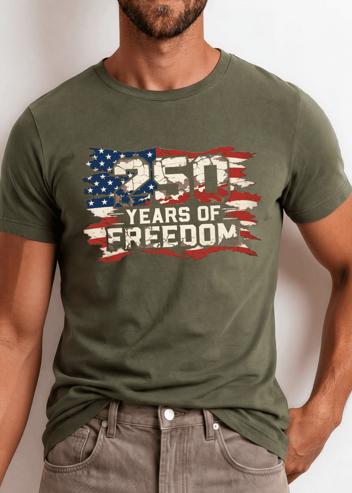250 Years of Freedom Distressed Flag Tee — Made in USA. Bold cracked flag graphic on Army Green, soft 100% cotton, relaxed fit. Perfect for 4th of July. Sizes S-2XL.
