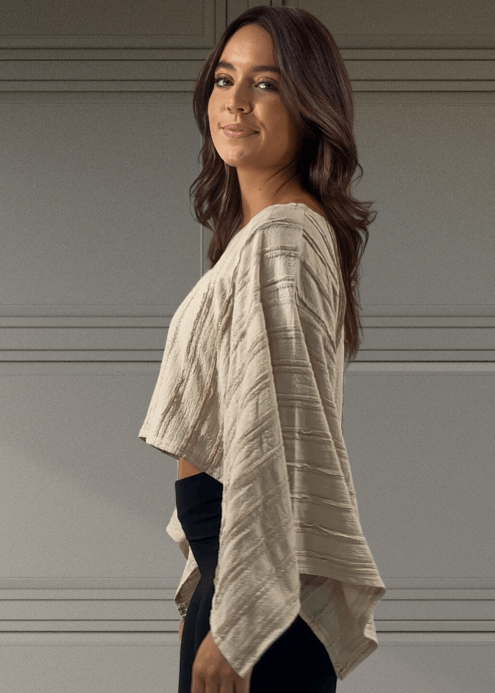 Embrace effortless style with this Kimono Sleeve Cropped Top in a soft beige hue. Featuring a round neck and breezy 3/4 kimono sleeves, its oversized, flowy fit pairs perfectly with the cropped length for a playful, modern look. 