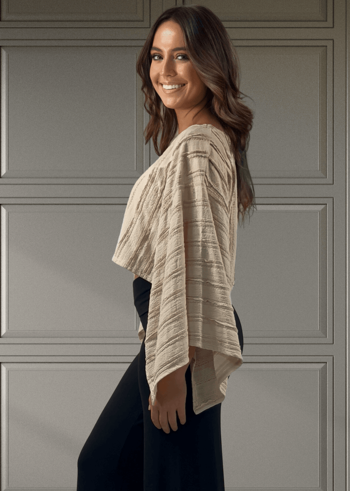 Embrace effortless style with this Kimono Sleeve Cropped Top in a soft beige hue. Featuring a round neck and breezy 3/4 kimono sleeves, its oversized, flowy fit pairs perfectly with the cropped length for a playful, modern look. 