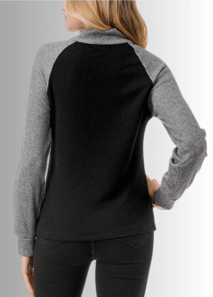 This Paige Color Block Zip Detail Top offers a sleek, semi-fitted silhouette crafted from medium-weight fabric, perfect for layering or standalone wear. Featuring a stylish quarter zip front and a modern black and gray color block design, it combines comfort with contemporary appeal. Made in the USA