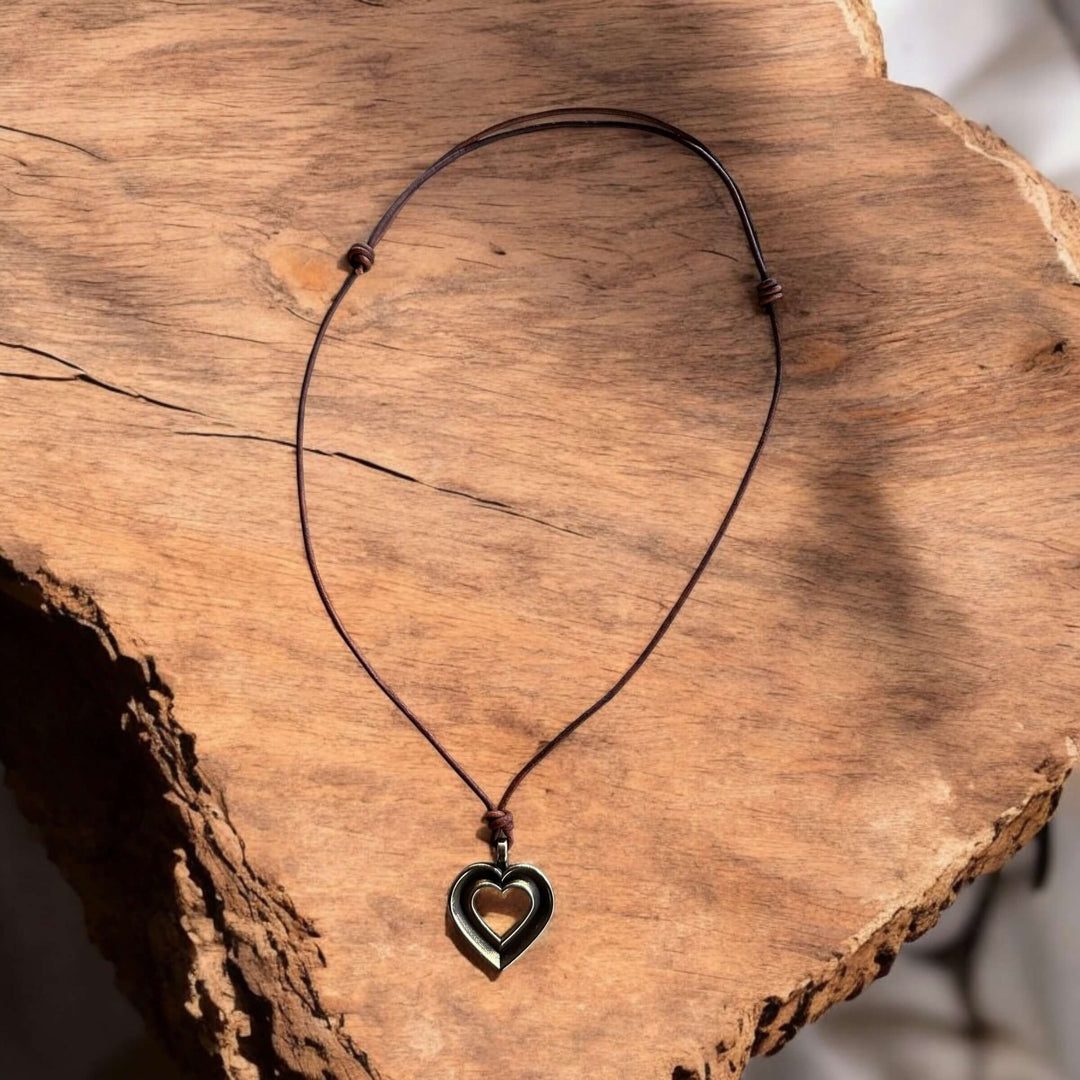 Handcrafted solid bronze LOVE heartbeat necklace on an adjustable leather cord. Made in USA with a lifetime warranty