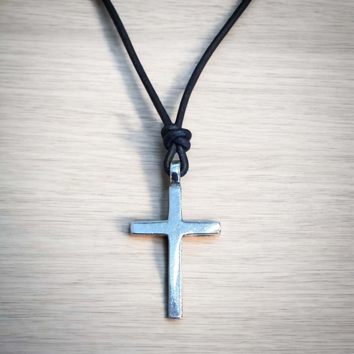 Handcrafted solid sterling silver cross on an adjustable leather cord. Unisex. Available in black, dark brown, or red brown. Made in USA