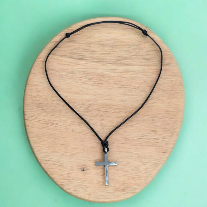 Handcrafted solid sterling silver cross on an adjustable leather cord. Unisex. Available in black, dark brown, or red brown. Made in USA