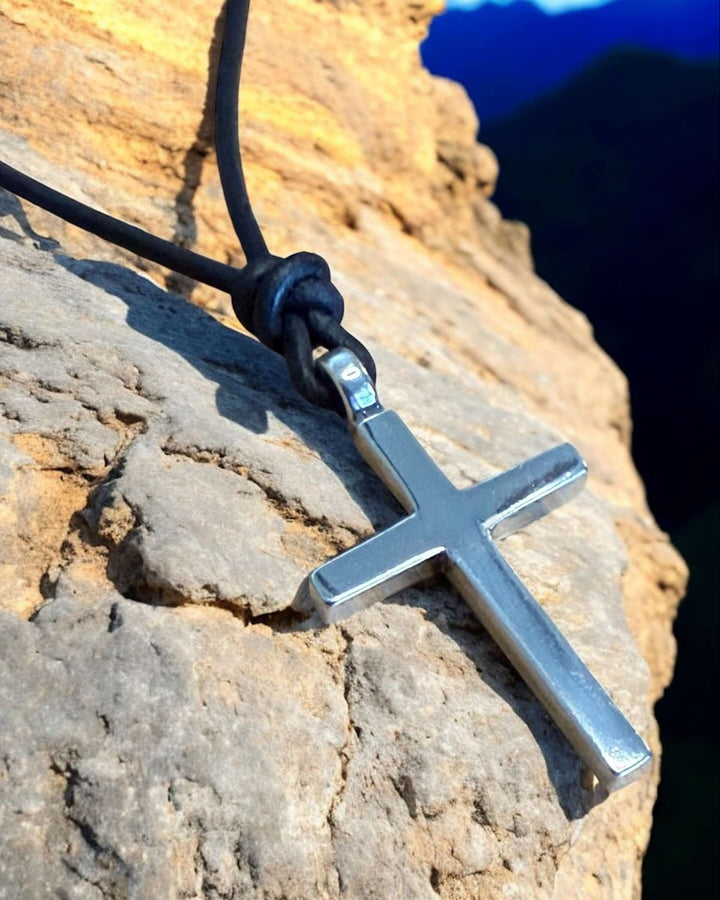 Handcrafted solid sterling silver cross on an adjustable leather cord. Unisex. Available in black, dark brown, or red brown. Made in USA