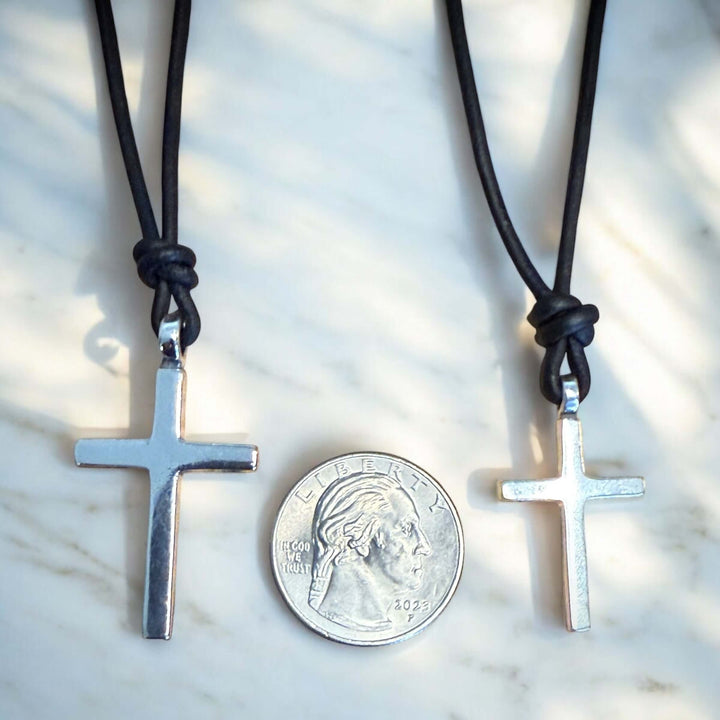 Handcrafted solid sterling silver cross on an adjustable leather cord. Unisex. Available in black, dark brown, or red brown. Made in USA