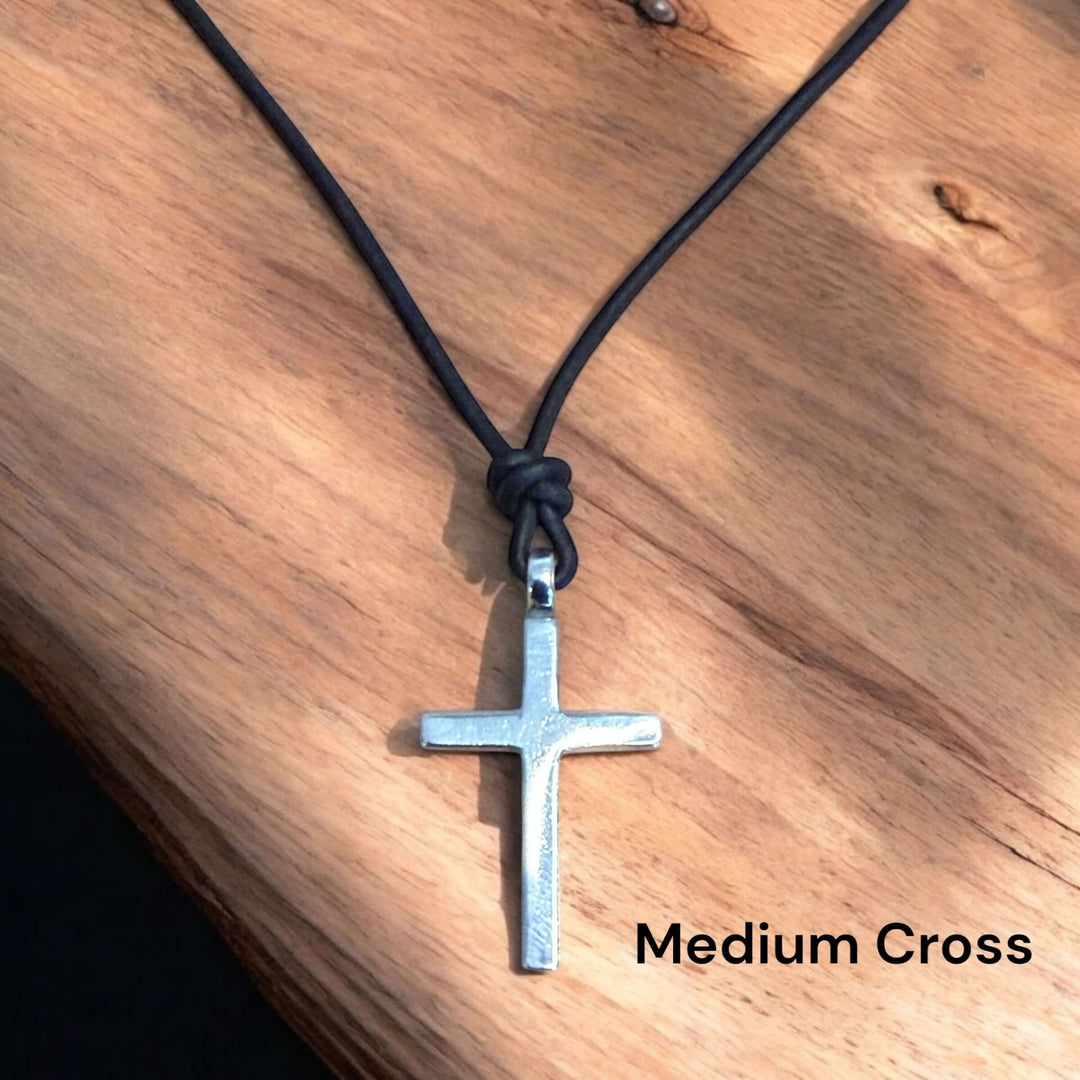 Handcrafted solid sterling silver cross on an adjustable leather cord. Unisex. Available in black, dark brown, or red brown. Made in USA