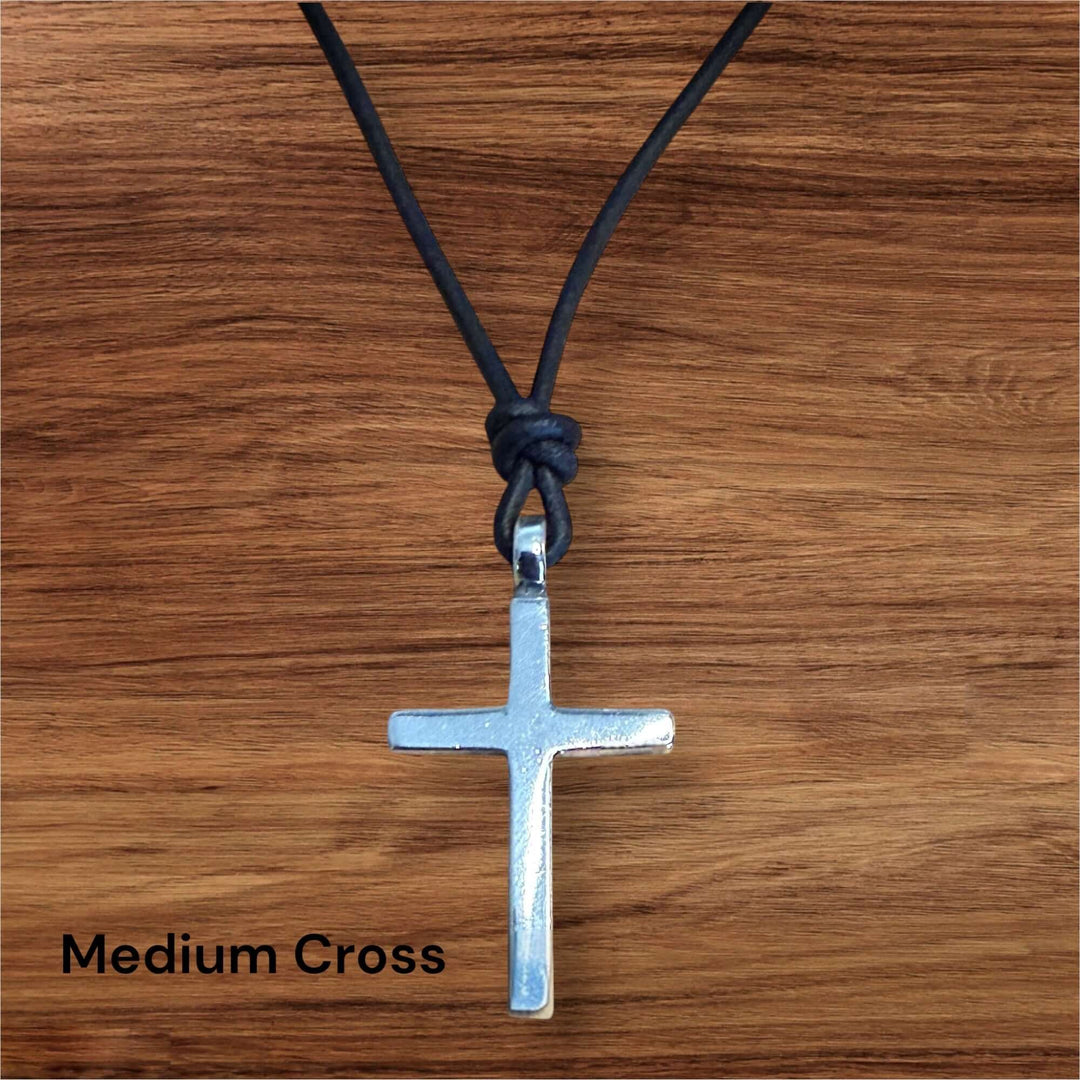 Handcrafted solid sterling silver cross on an adjustable leather cord. Unisex. Available in black, dark brown, or red brown. Made in USA
