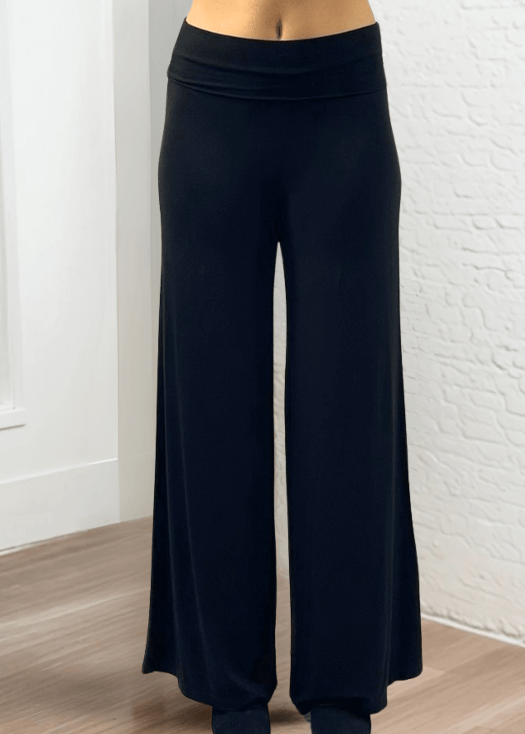 Experience ultimate comfort and style with these Soft Rayon Jersey Palazzo Pants in Solid Black, crafted in the USA. Featuring a flattering fold-over waist and a wide-leg silhouette, they offer a relaxed yet chic look. Made from a stretchy blend of rayon and spandex, these pants move with you while maintaining their softness.