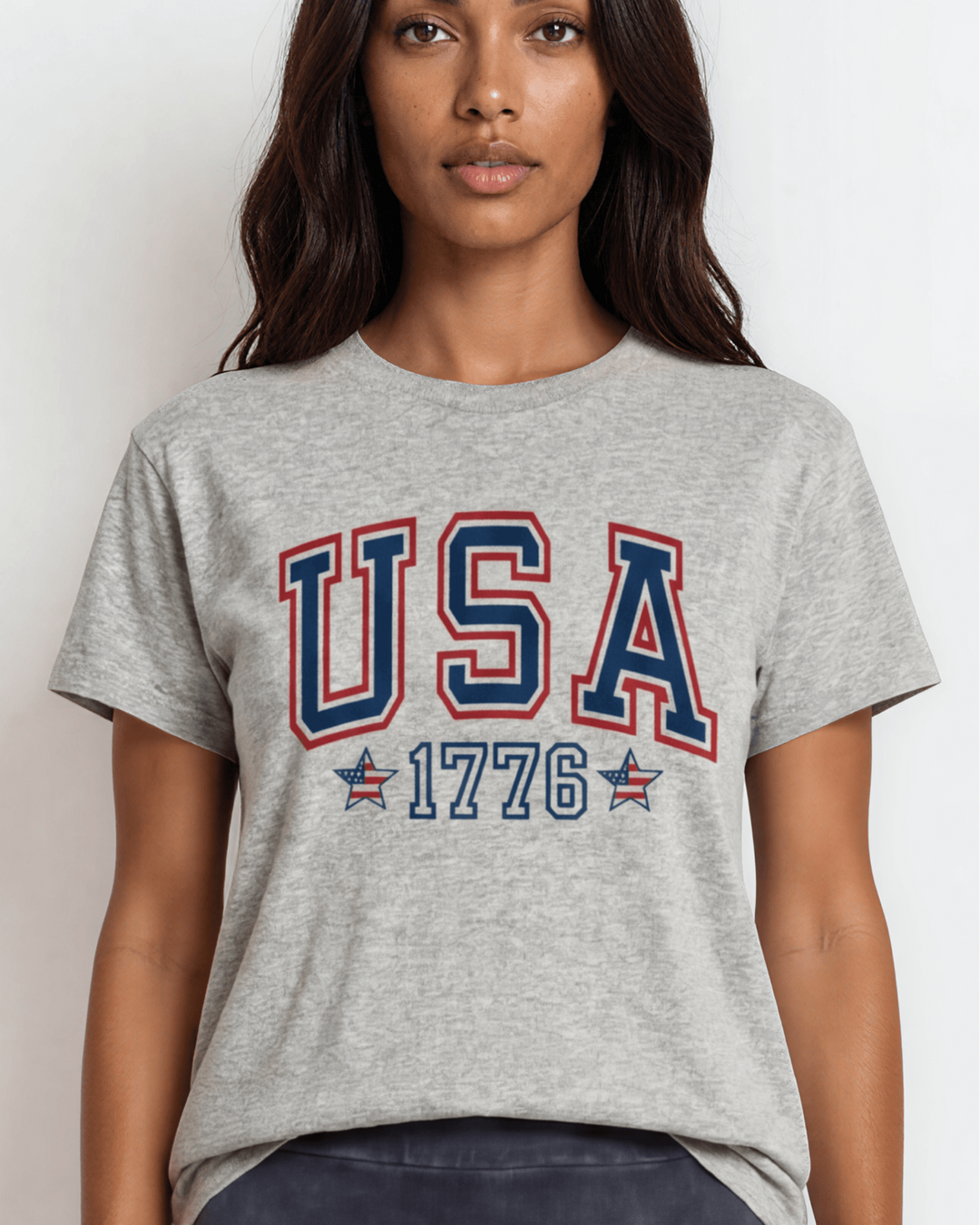 Women's USA 1776 collegiate graphic tee made in USA. Bold navy & red lettering with flag stars on heather gray 100% cotton. Relaxed fit, XS-3X. Perfect for 4th of July.