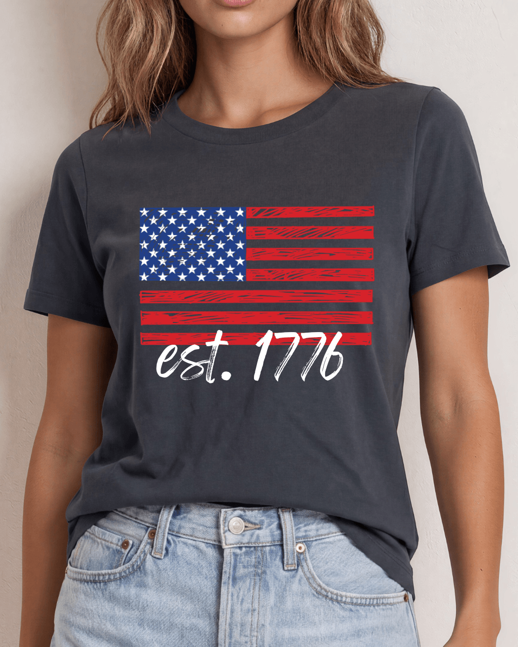 True American Women's T-Shirt with Patriotic American flag graphic tee with est. 1776 script. 100% combed ring-spun cotton, made in USA. Available in Graphite Gray and Black.