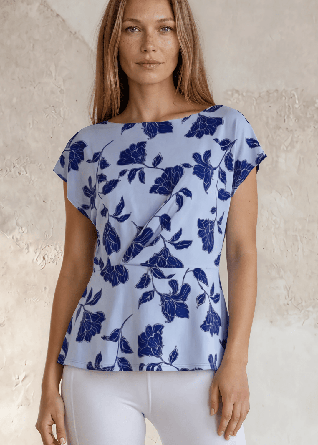USA-made women's light blue and navy floral twist-front blouse. Bateau neckline, cap sleeves, flattering waist detail