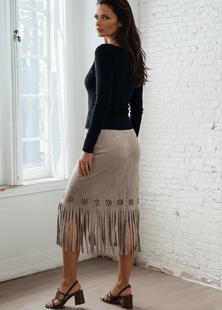 Add a unique piece to your wardrobe with the Leia Laser Cut Fringe Overlay Suede Skirt, a statement piece crafted right here in the USA. This skirt features an intricate laser-cut floral pattern with delicate fringe detailing and a chic wrap overlay silhouette that flatters every figure. 